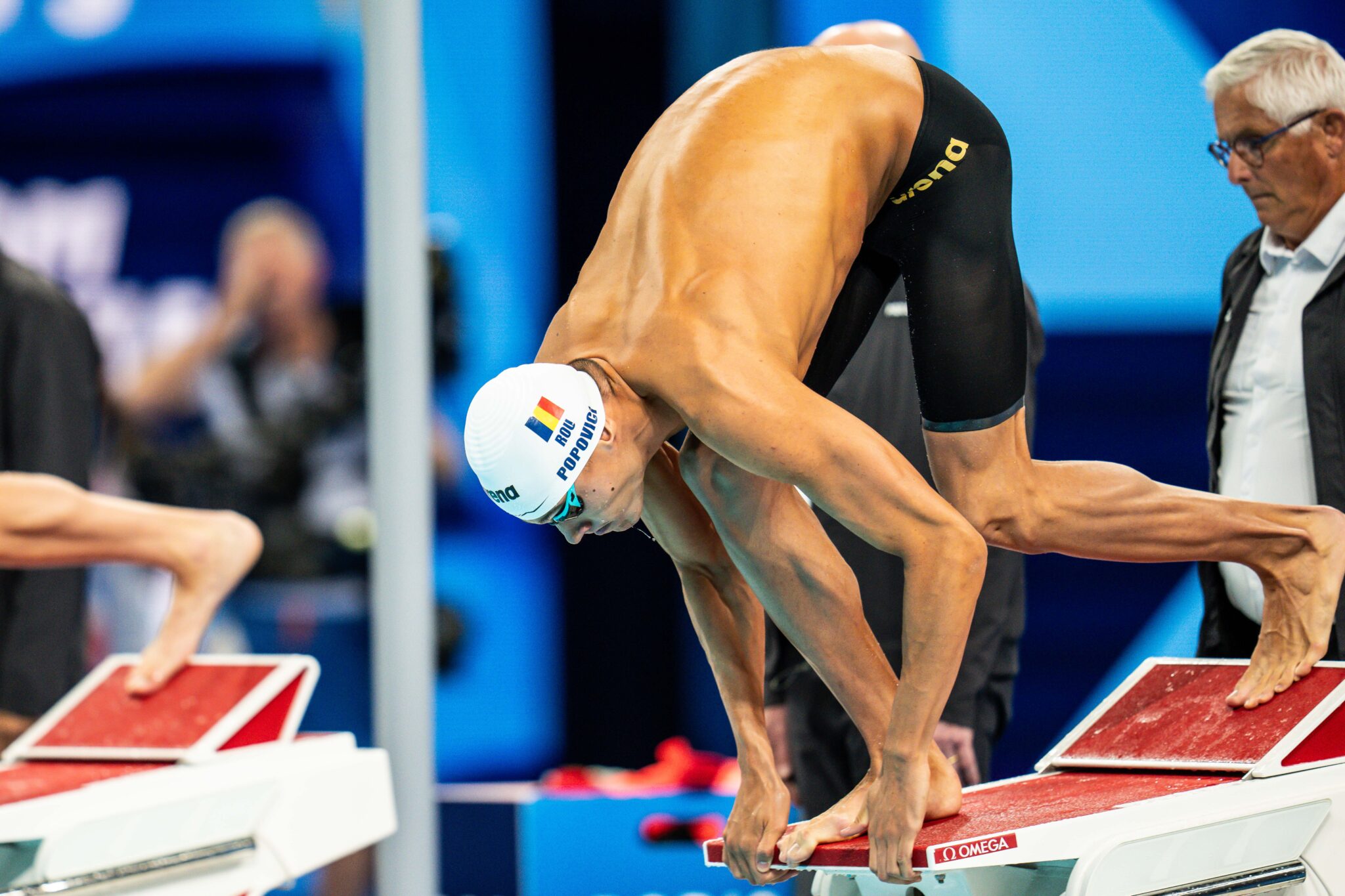 Teammates laughing on the pool deck after training.